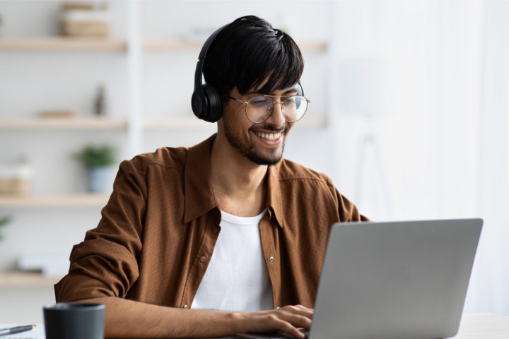 man at computer with headphones